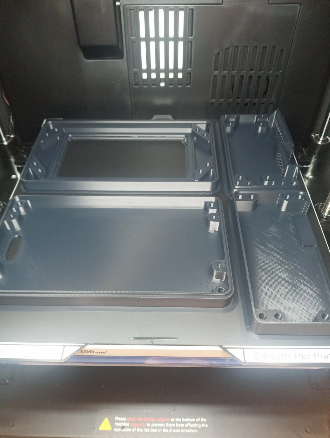 Plusieurs éléments de boîtiers XPR3® EMS imprimés ensemble sur un plateau de fabrication